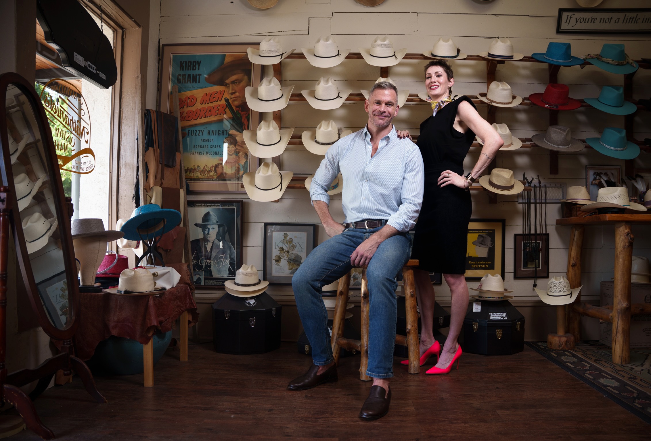 Drew and Kelly in a hat shop with hats on the wall