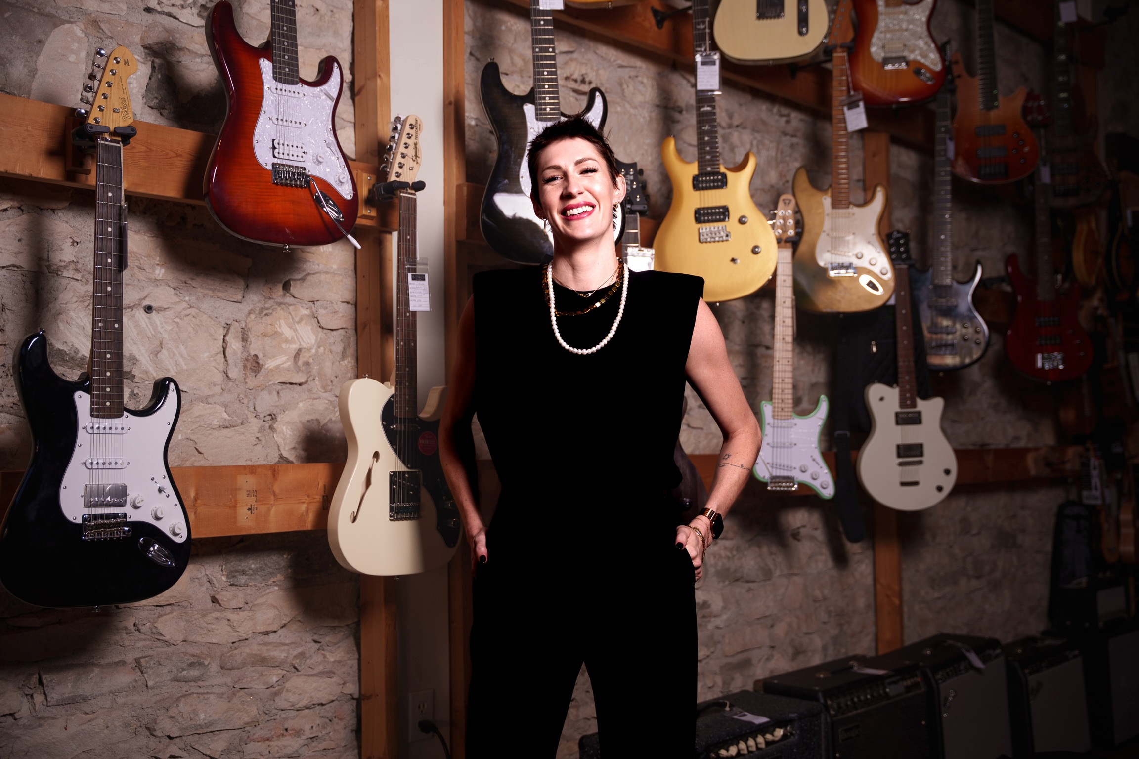 Kelly Corcoran smiling in a guitar shop
