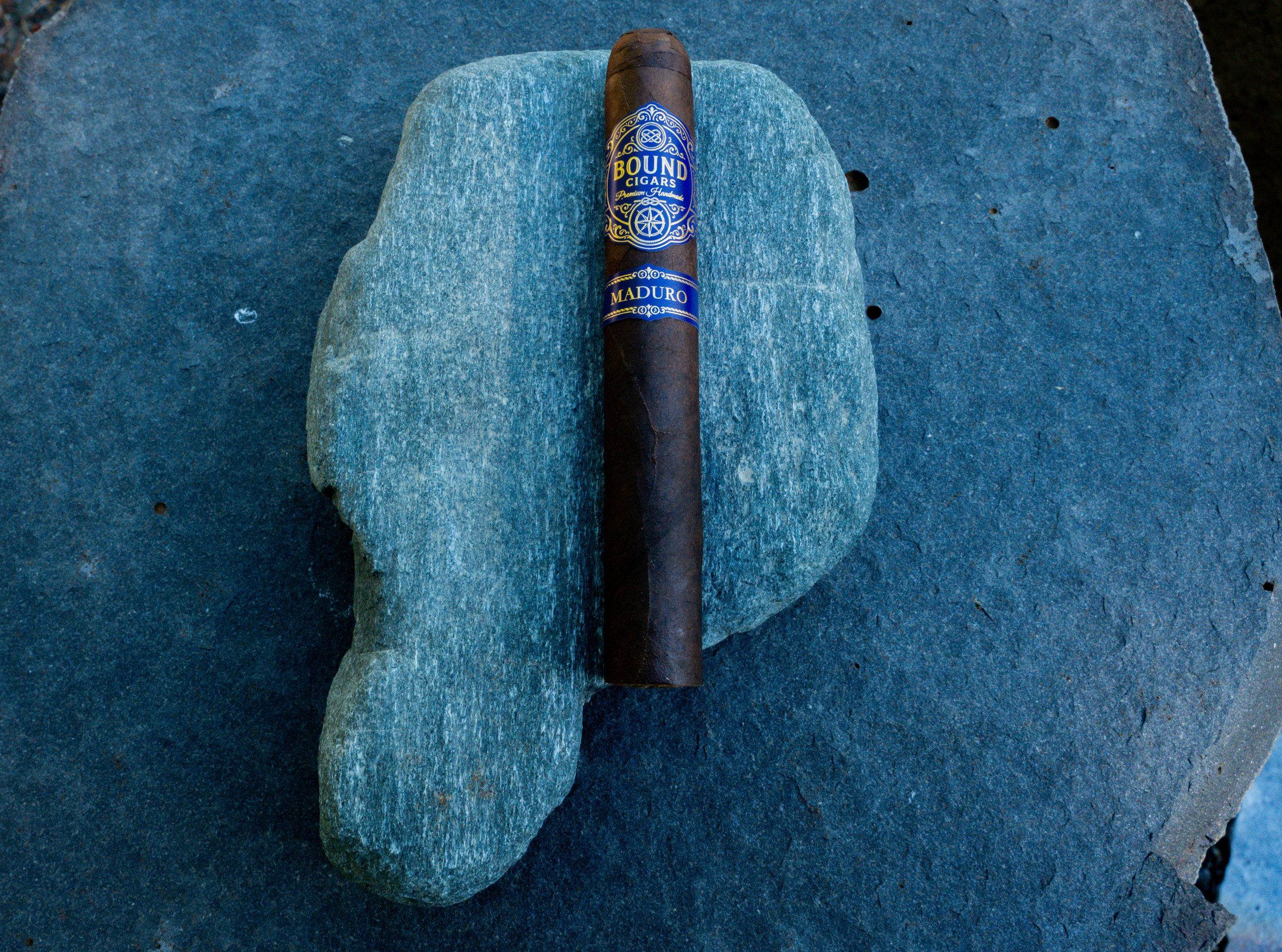 Northbound Maduro cigar resting on a green stone