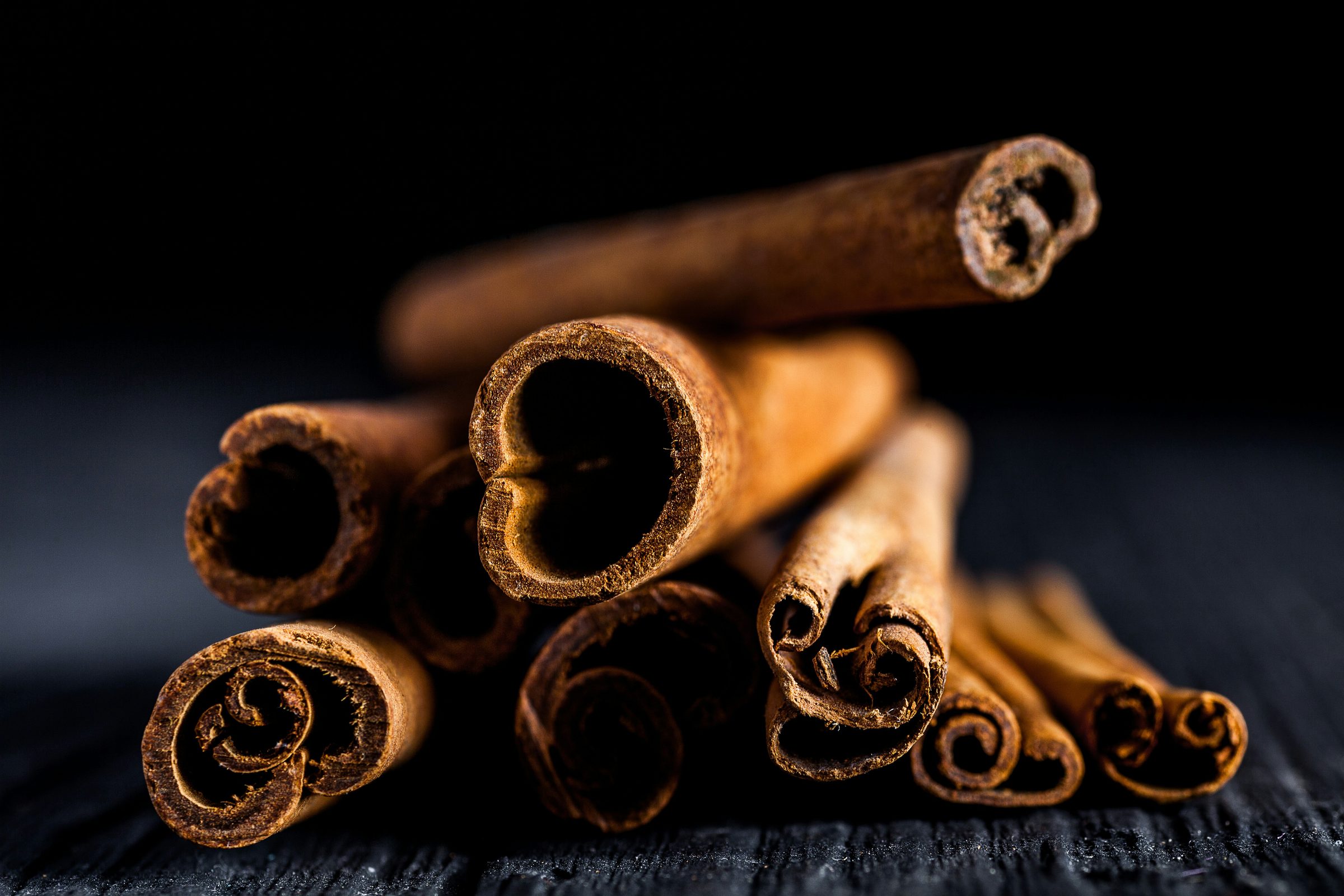 Cinnamon sticks on a dark surface